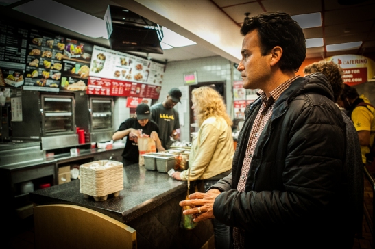 Homero Hidalgo, 35, part time postmates courier waits inside KFC/Taco Bell on Duboce Avenue to pick up the food order for the customer who requested delivery through the Postmates app on Friday, July 17, 2015. (Photo by Ekevara Kitpowsong/Bay News Rising)